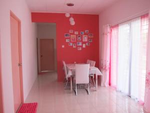 a dining room with a table and a red wall at MILU Homestay - Kuala Selangor in Kuala Selangor