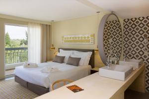a hotel room with two beds and a mirror at OZADI Tavira Hotel in Tavira