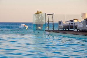 een zwembad met een bed en een boot in het water bij The Sindbad in Hammamet