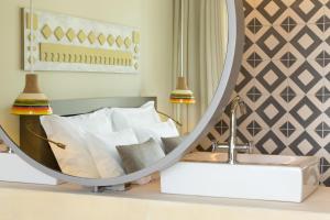 a bedroom with a bed and a mirror at OZADI Tavira Hotel in Tavira