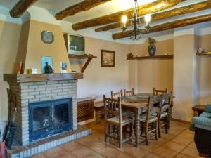 a living room with a fireplace and a table and chairs at Casas Rurales Encarnita in Bubión