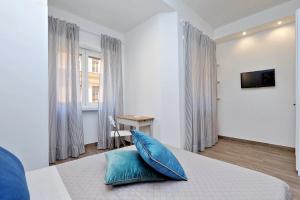 um quarto com uma cama com duas almofadas azuis em La Finestra sul Vaticano em Roma