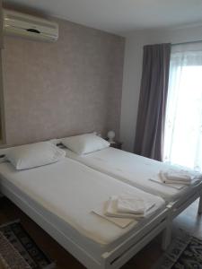 1 cama blanca grande con 2 toallas en Roza Guest House, en Senj