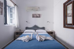 a bedroom with a bed with two towels on it at Maryloujohn Villas Oia in Oia
