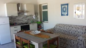 Villaggio AzzurroにあるL'Ancora Azzurraのリビングルーム(テーブル付)、キッチン(ソファ付)
