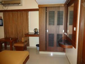 班加羅爾的住宿－西塔爾住宿酒店，客厅配有木制橱柜和桌子