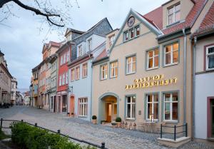 une rue pavée dans une ville avec des bâtiments dans l'établissement Gasthof Zufriedenheit, à Naumbourg