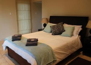 a bedroom with a large bed with towels on it at Die Bult Plaas Guesthouse in Marchand +20 photos