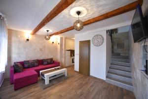 a living room with a pink couch and a tv at Villa Old Olive 2 in Budva