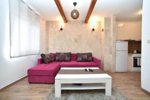 a living room with a pink couch and a coffee table at Villa Old Olive 2 in Budva