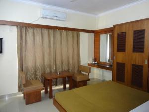 a bedroom with a bed and a desk and a window at Sheetal Residency in Bangalore