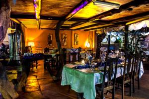 uma sala de jantar com mesas e cadeiras num quarto com tectos em Dei Gratia Guest House em Musina