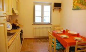 奧爾維耶托的住宿－Casale di Romealla，厨房配有红色的桌椅和窗户