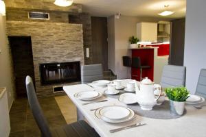 a dining room with a table and a fireplace at Park Apartament in Rzeszów