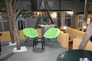 a room with two green chairs and a tree at Lisboa Sunshine Homes in Lisbon