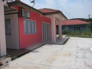 une maison rouge avec une allée devant elle dans l'établissement MILU Homestay - Kuala Selangor, à Kuala Selangor