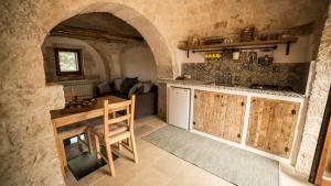 a kitchen with a counter and a table in a room at B&B Trulli Mansio in Alberobello