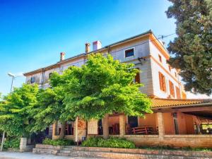 an old building with a tree in front of it at Apartments Fazanka 849 in Fažana