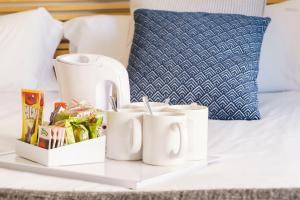 a tray with mugs and a tea set on a bed at BYPILLOW House in Barcelona