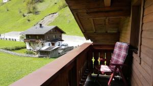 a rocking chair sitting on a porch with a house at Gasperlerhof in Neustift im Stubaital