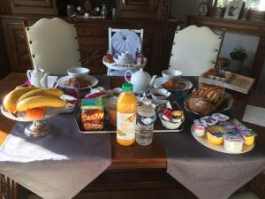 uma mesa com alimentos e bebidas para o pequeno almoço em La Mansarde em Neuville-sous-Montreuil