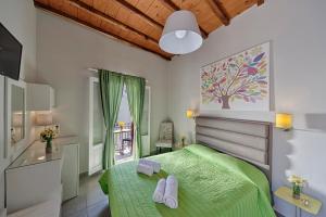 a bedroom with a green bed and a window at Paradise in Ermoupoli