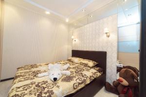 a bedroom with a bed with a teddy bear on it at Apartment on Pritomskiy prospekt in Kemerovo