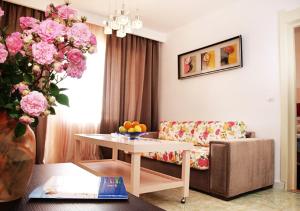 a living room with a table and pink flowers at Hotel Majestic Mamaia Half Board & All Inclusive in Mamaia +42 photos