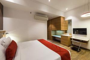 1 dormitorio con 1 cama grande y TV en Urban Hermitage, en Nagpur