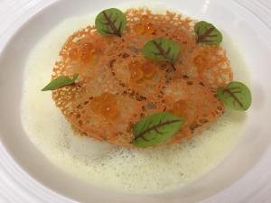 a plate of food with orange sauce and green leaves at Thalacap Île de Ré - Thalasso & Spa in Ars-en-Ré