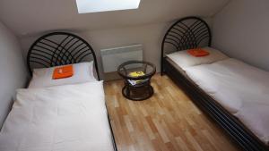 two beds in a small room with orange folders at Pension Úsvit in Podkopná Lhota