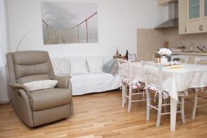 a living room with a table and chairs and a couch at Apartman Allegria in Zagreb