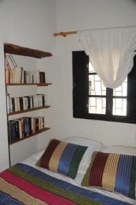 a bedroom with a bed and a window with books at Riad Darbask in Essaouira