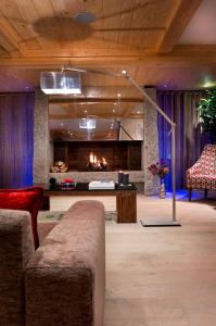 - un salon avec un canapé et une cheminée dans l'établissement CGH Résidences & Spas Le Cristal de l'Alpe, à L'Alpe-d'Huez