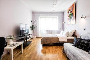 a living room with a bed and a couch at Apartment 4You Piter ThreE in Saint Petersburg