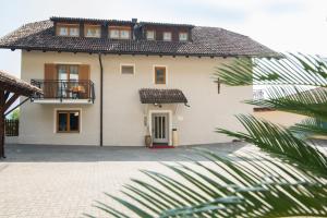a large white house with a balcony at Garni Gartenheim in Caldaro