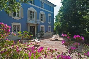 a blue house with flowers in front of it at Resort Dei Limoni in Lucca