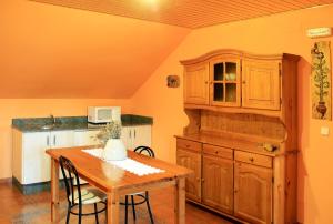 cocina con mesa de madera y armario de madera en Alojamiento en entorno rural Los Trobos, en Villar de Otero