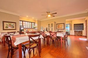 a dining room with tables and chairs and a ceiling fan at Leopardsong Manor in Centurion