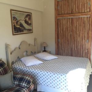 a bedroom with a bed and a chair at Apartamento Cavalinho Branco 501 in Águas de Lindóia