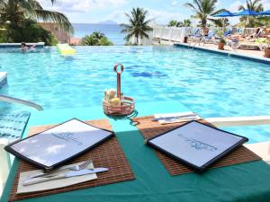 a table with plates and utensils next to a swimming pool at La Vista Resort in Simpson Bay