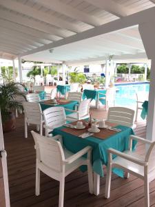 a patio with tables and chairs and a pool at La Vista Resort in Simpson Bay