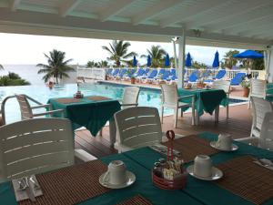 een patio met tafels en stoelen en een zwembad bij La Vista Resort in Simpson Bay