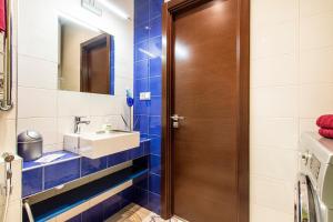 a bathroom with a sink and a wooden door at Apartment 4You Piter ThreE in Saint Petersburg