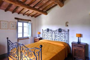 a bedroom with a bed with an orange bedspread and a window at Agriturismo Pian Del Tevere in Torgiano +39 photos