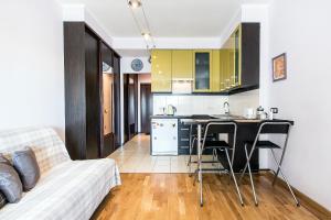 聖彼得堡的住宿－Apartment 4You Piter ThreE，厨房以及带沙发和桌子的客厅。