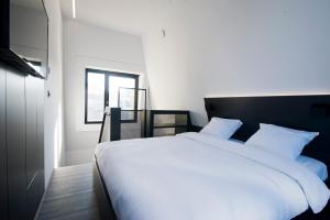 a bedroom with a large white bed and a window at Sleep Well Youth Hostel in Brussels