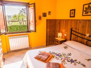 a bedroom with yellow walls and a bed and a window at Il Fontanile in Marina di Grosseto