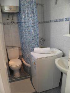 a bathroom with a toilet and a shower curtain at Apartment Adria in Trogir +40 photos