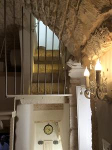 奧斯圖尼的住宿－Casa Pietra e Sole，墙上挂着时钟的房子里的楼梯间